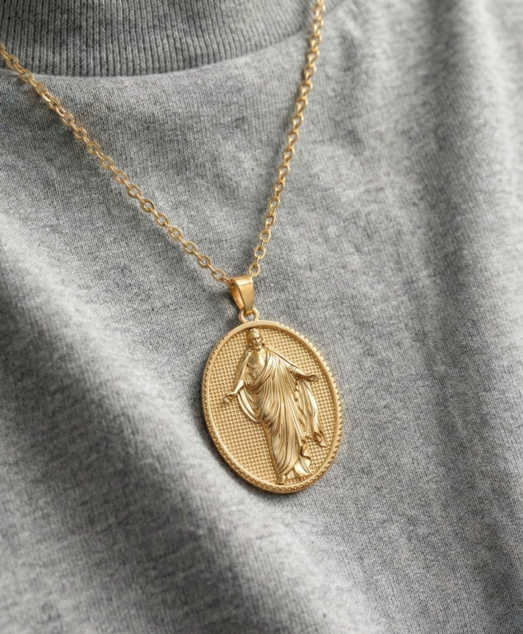 Dije religioso de Jesús Resucitado con detalles en relieve en oro laminado de 18 quilates